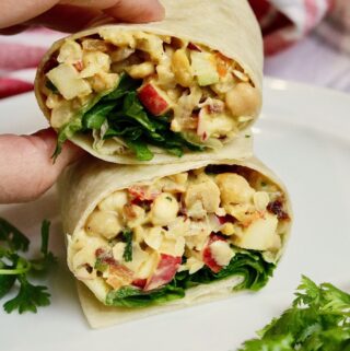 curried chickpea salad wrap sliced in half on a plate