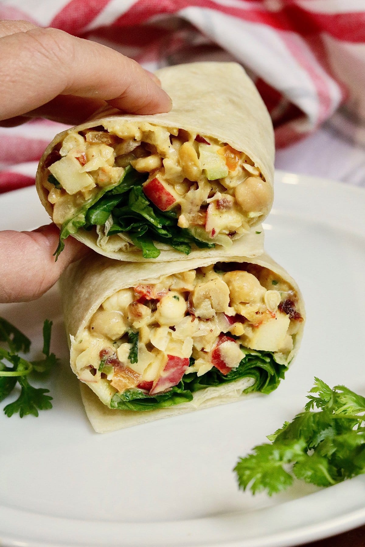 curried chickpea salad wrap sliced in half on a plate
