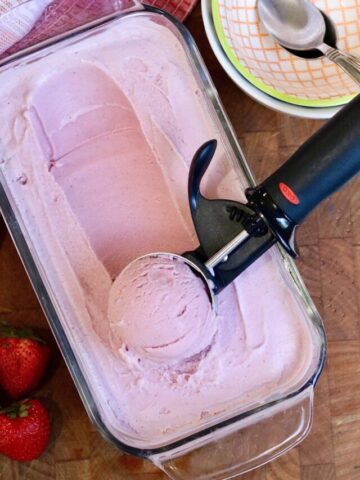 vegan strawberry ice cream being scooped into a bowl