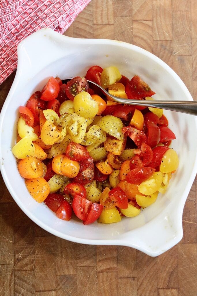 cherry tomatoes marinated in a bowl for pesto pasta