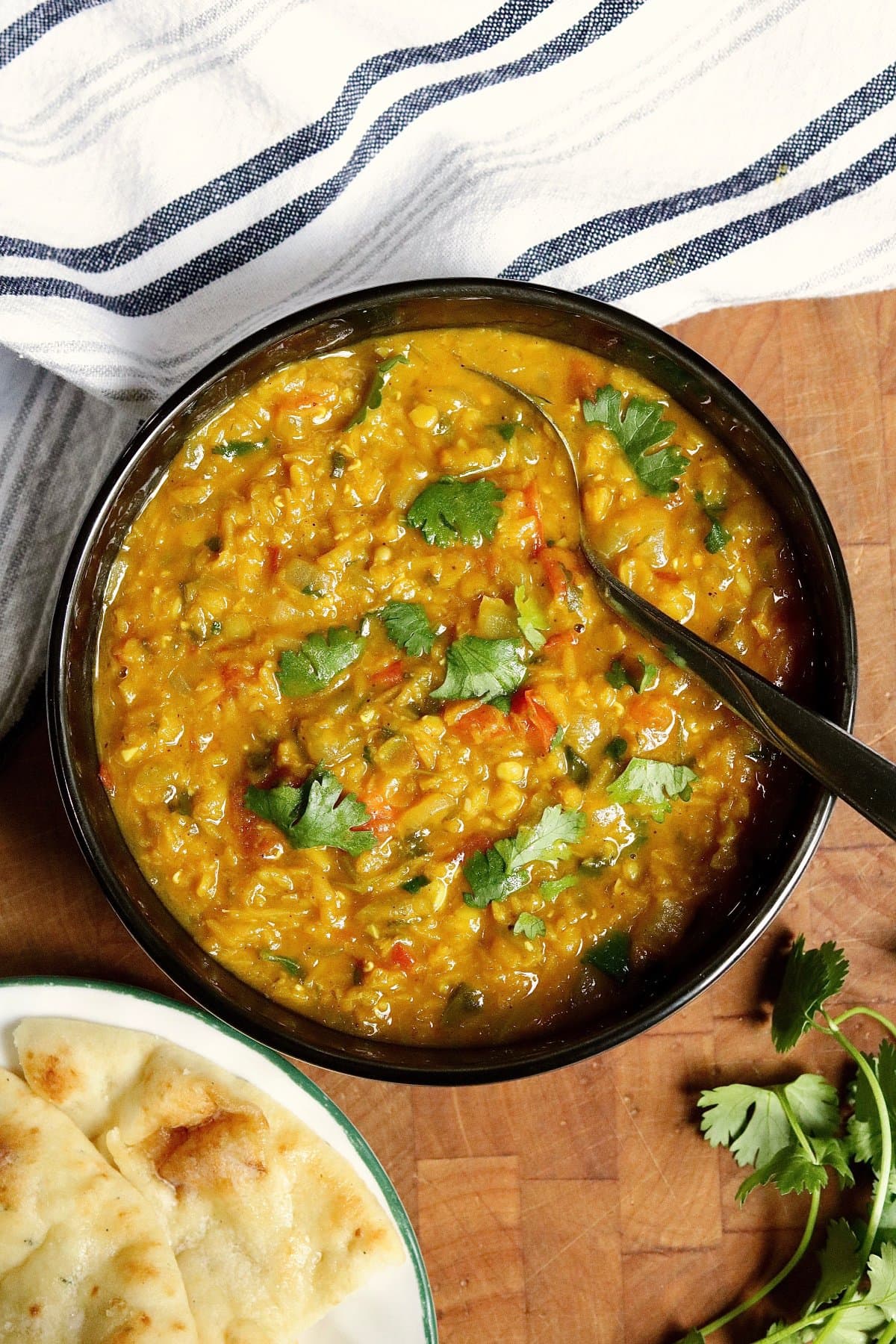 red lentil dahl in a bowl beside a plate of naan