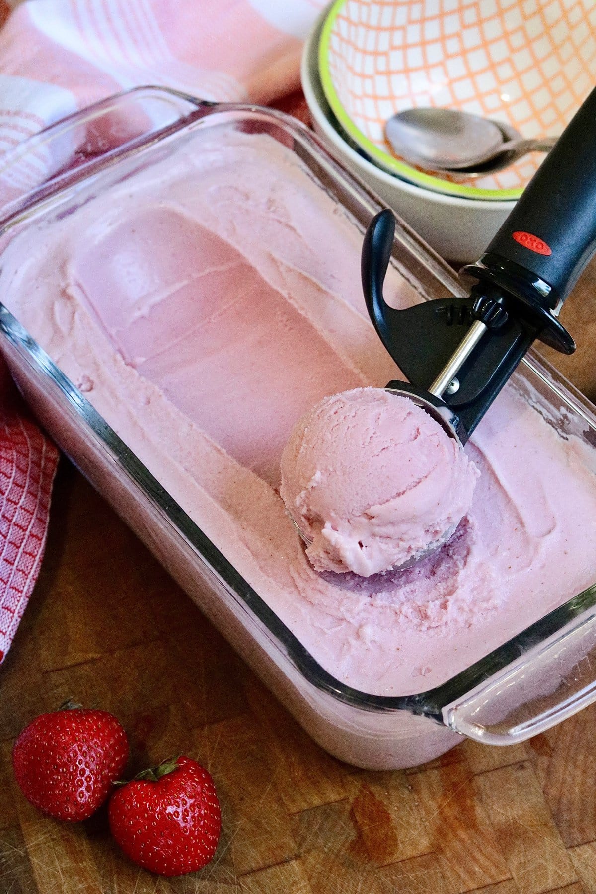 vegan strawberry ice cream being scooped out of container