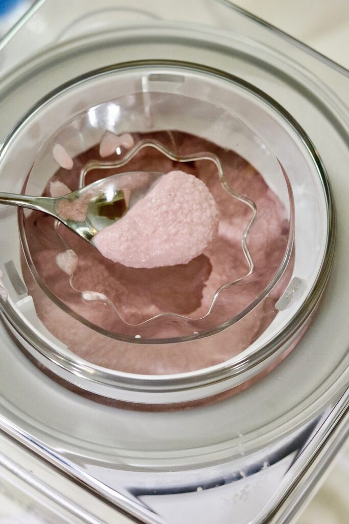 ingredients for vegan strawberry ice cream churning in ice cream maker
