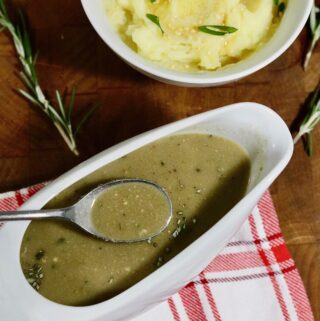 miso gravy in a gravy boat beside a bowl of mashed potatoes