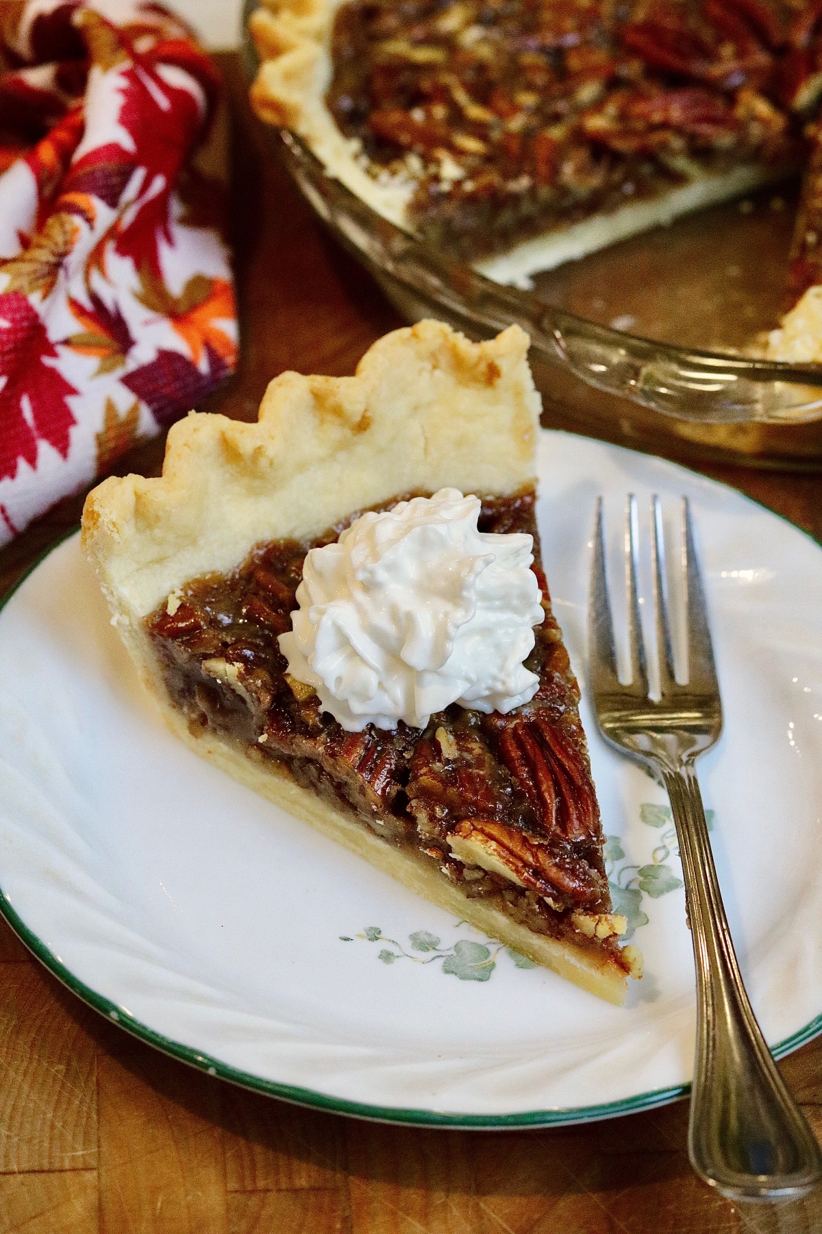 a slice of vegan pecan pie on a plate with whipped cream