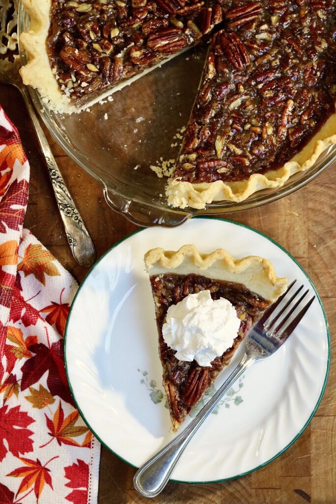 overhead view of slice of vegan pecan pie beside the whole pie