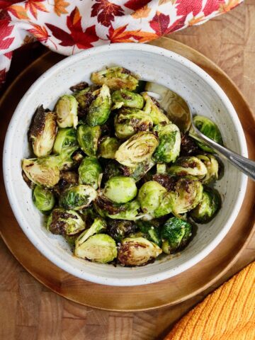 air fryer Brussels sprouts in a serving bowl tossed with balsamic miso glaze