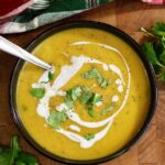 a bowl of vegan curried butternut squash soup with a spoon