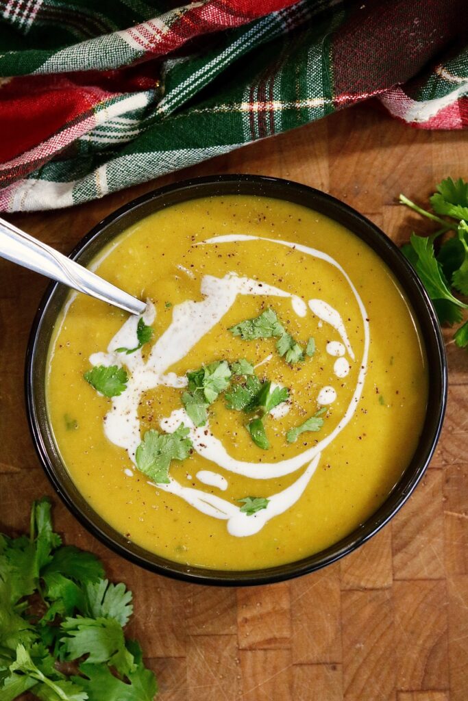 a bowl of vegan curried butternut squash soup with a spoon