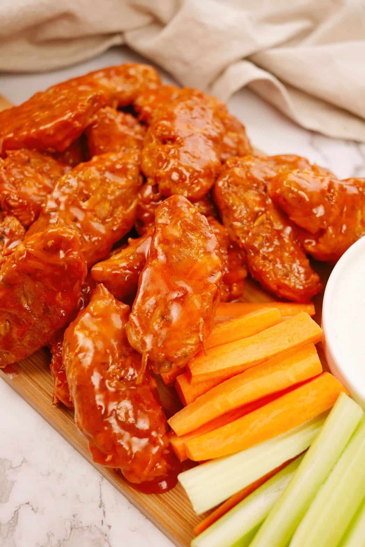 platter of jackfruit wings with buffalo sauce on table by cream napkin
