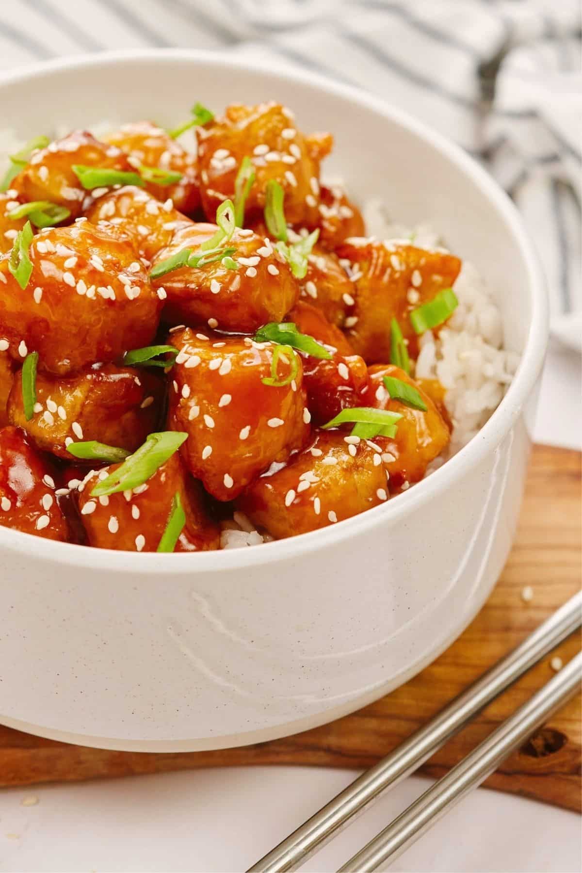 vegan sweet and sour tofu in white bowl on top of rice
