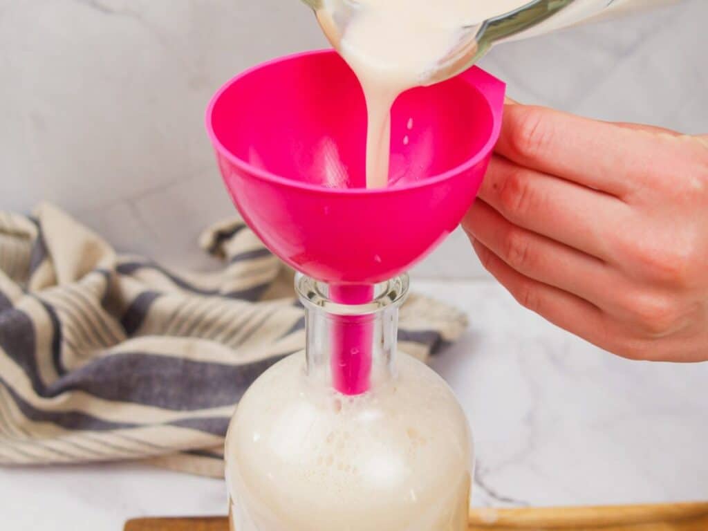 funnel being used to pour homemade Irish cream into jar