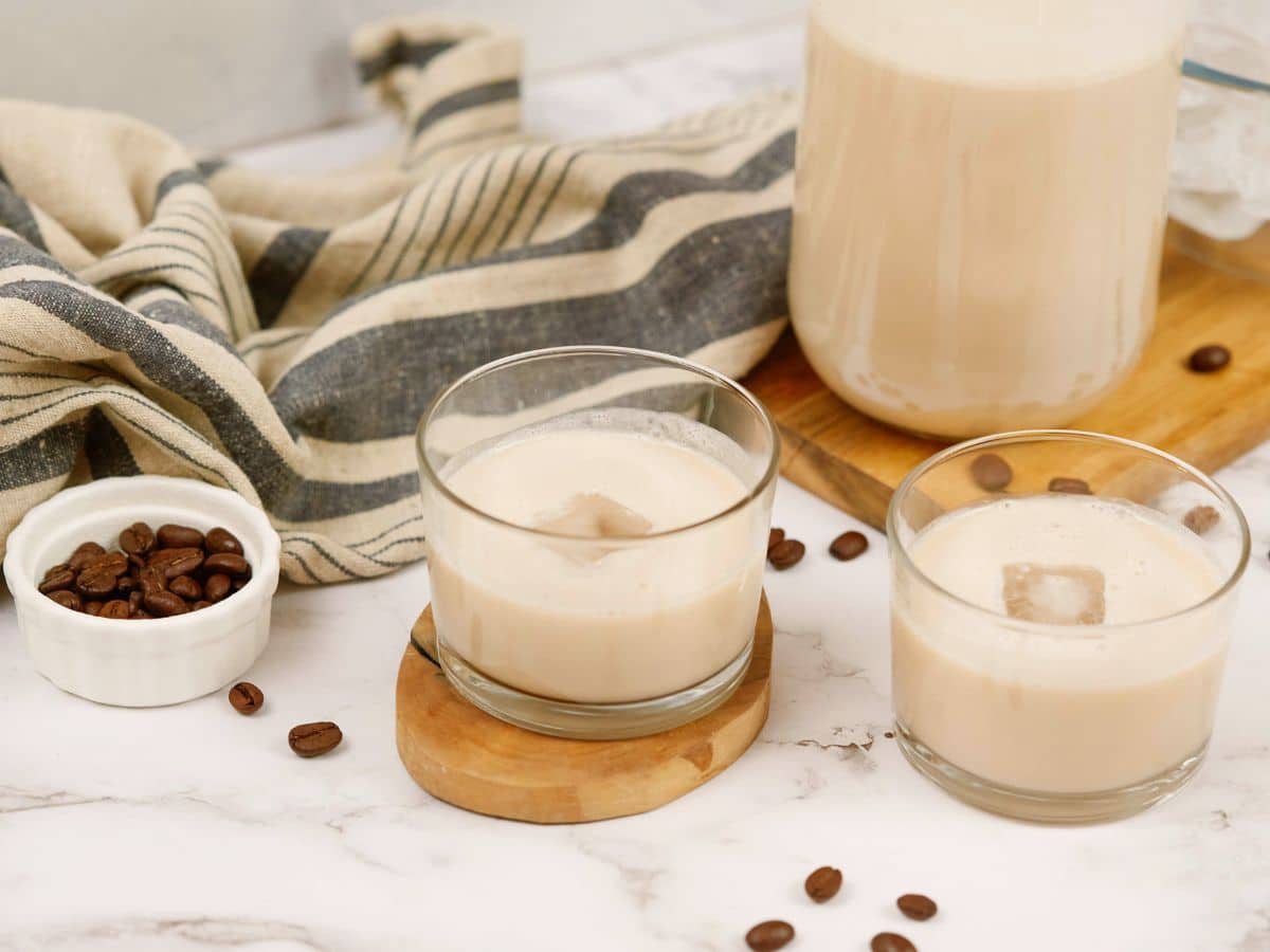 Irish cream in short glasses on table by coffee beans