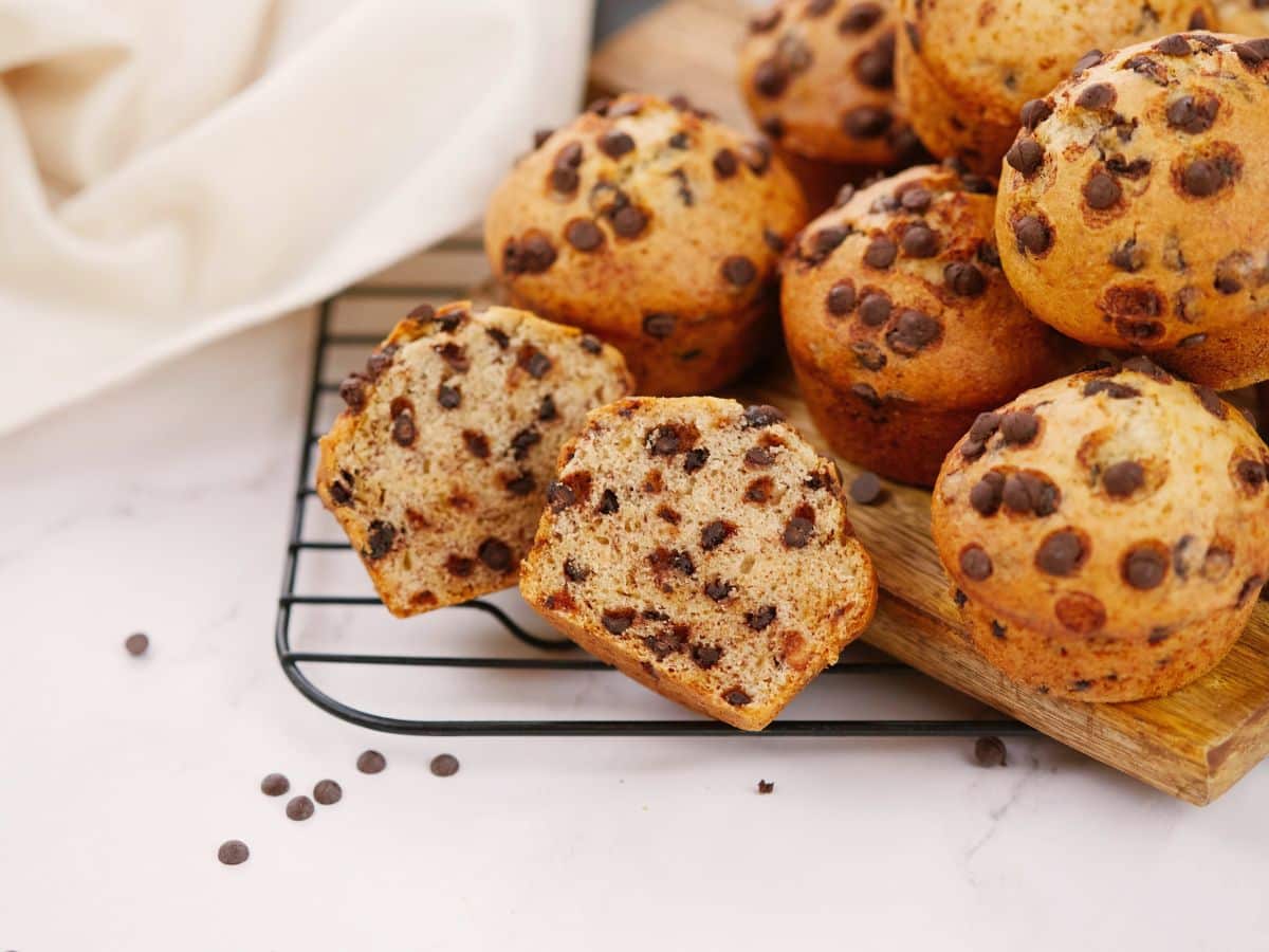 white table with black wire rack holding multiple vegan chocolate chip muffins