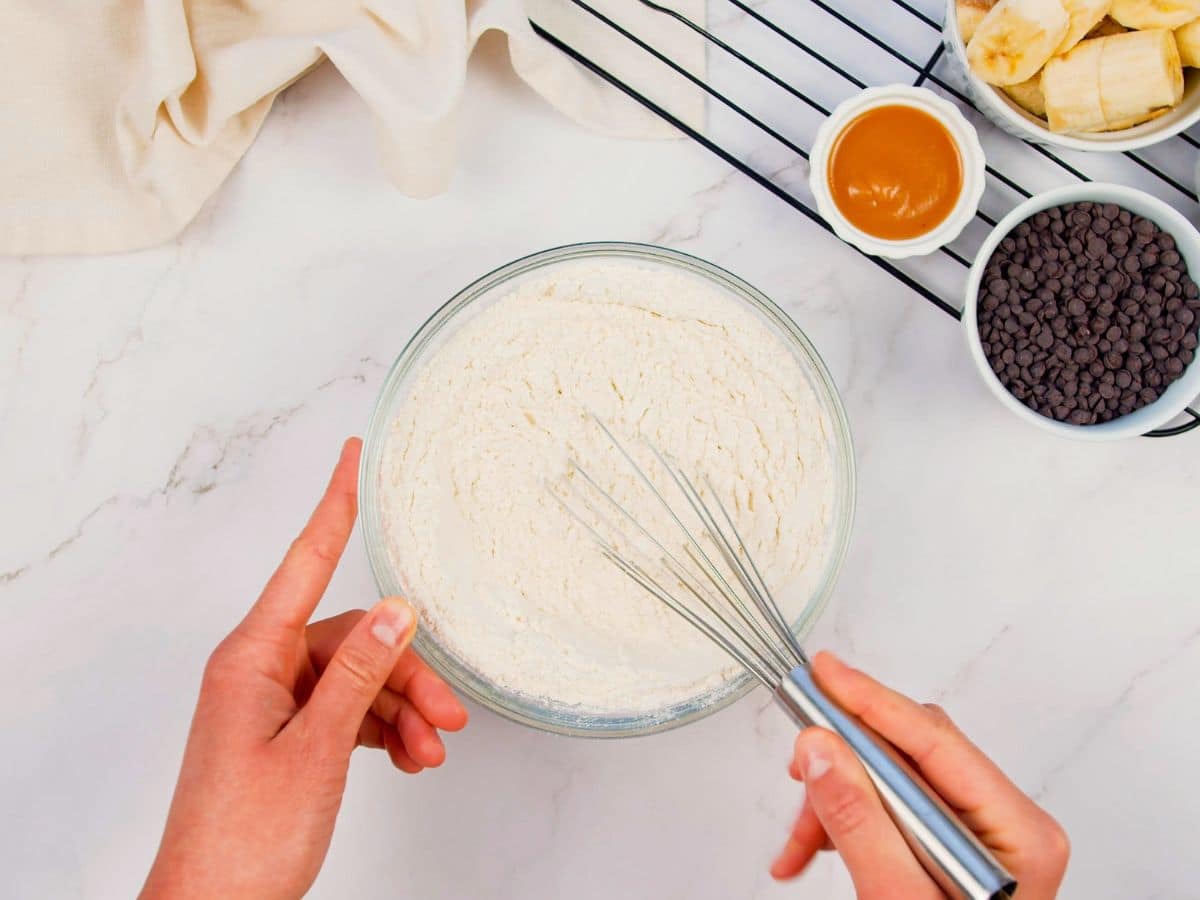 whisk in glass bowl of flour