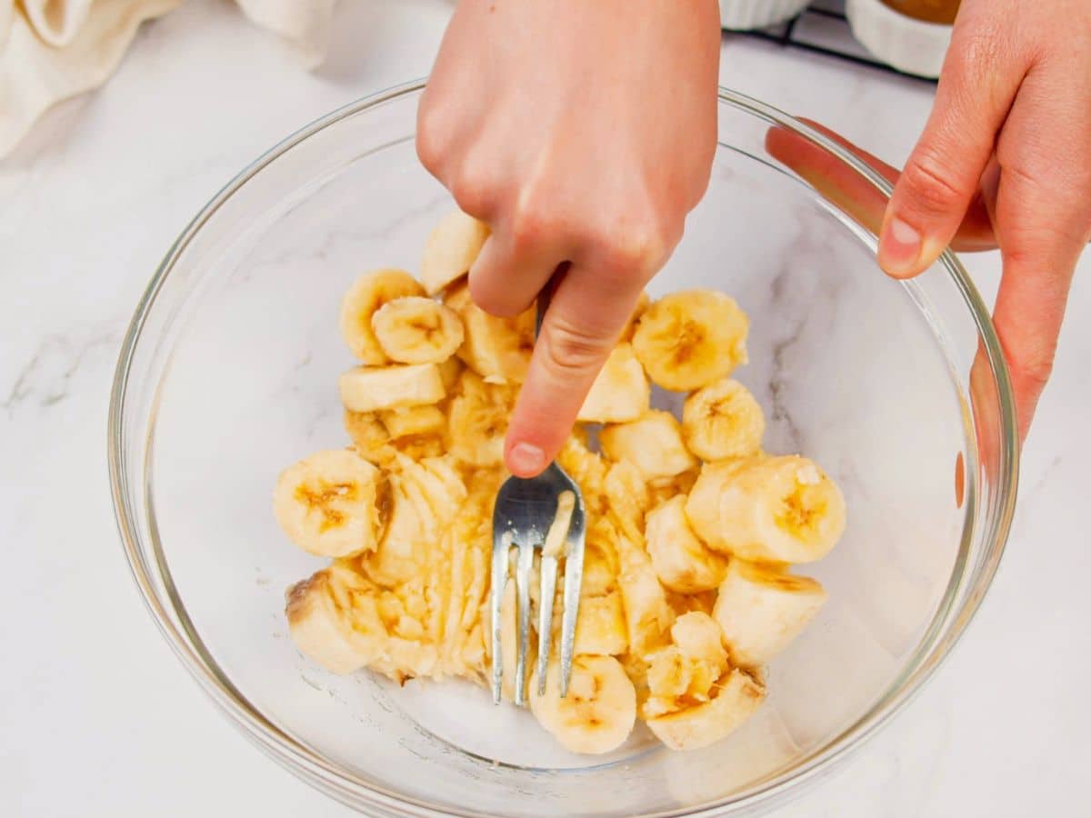 bananas being mashed in glass bowl