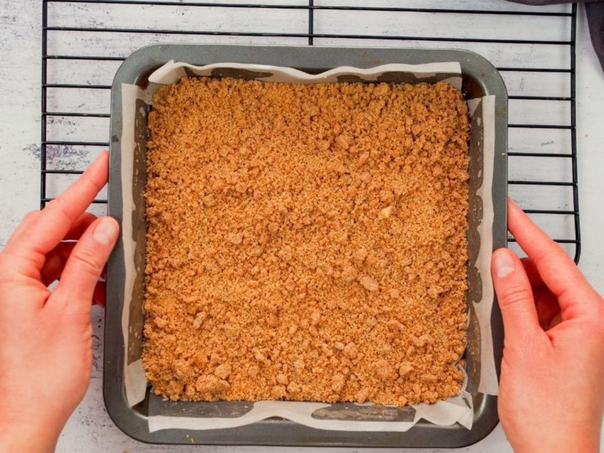 baked vegan coffee cake held above cooling rack