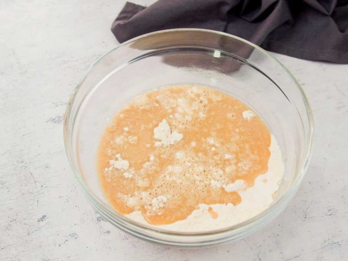 wet and dry ingredients being combined in large glass bowl