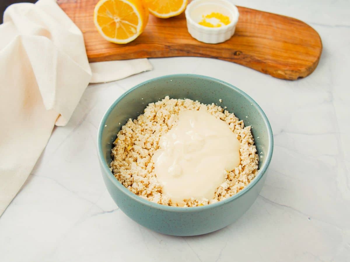 non diary yogurt in blue bowl with crumbled tofu