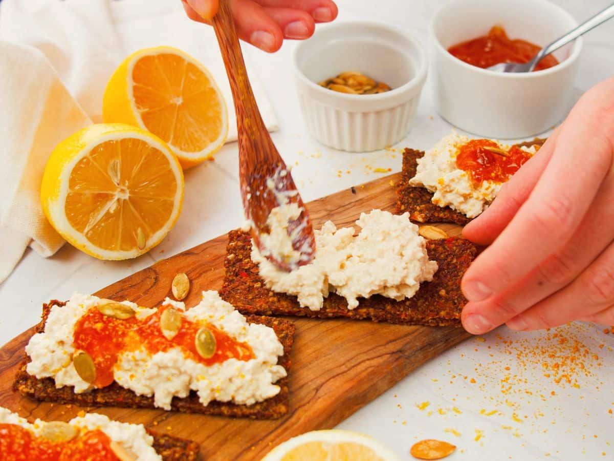 wooden spoon spreading cottage cheese on toast