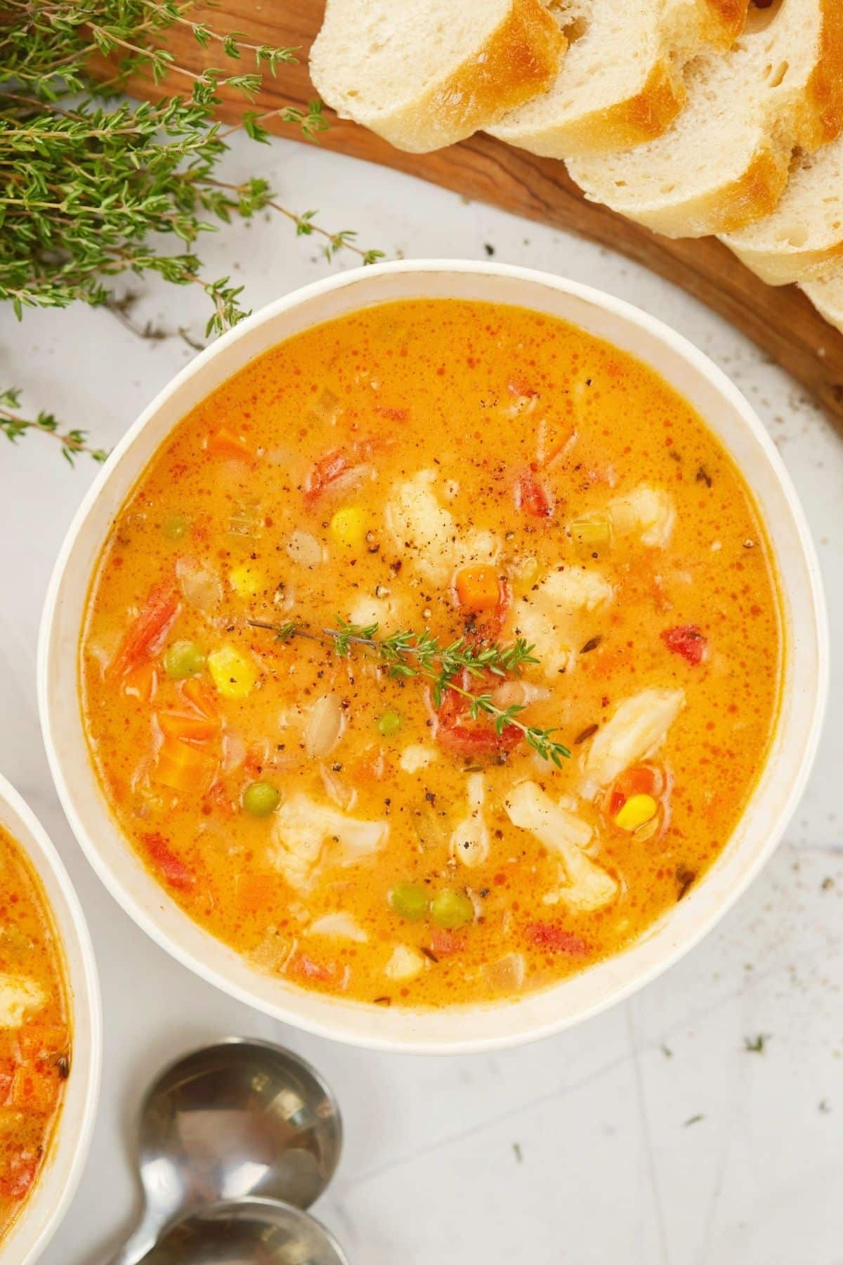 sprig of fresh thyme on top of bowl of vegetable soup