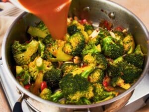 broth being poured into side of deep pan of broccoli