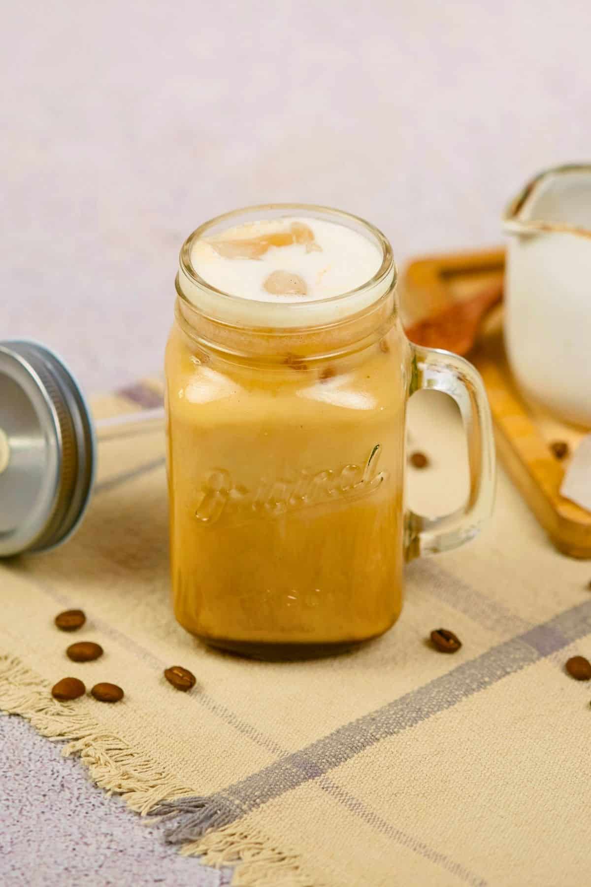 mason jar mug on table filled with brown sugar shaken espresso
