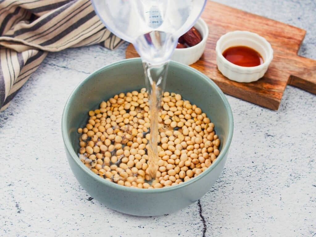 blue bowl of soy beans being covered in water