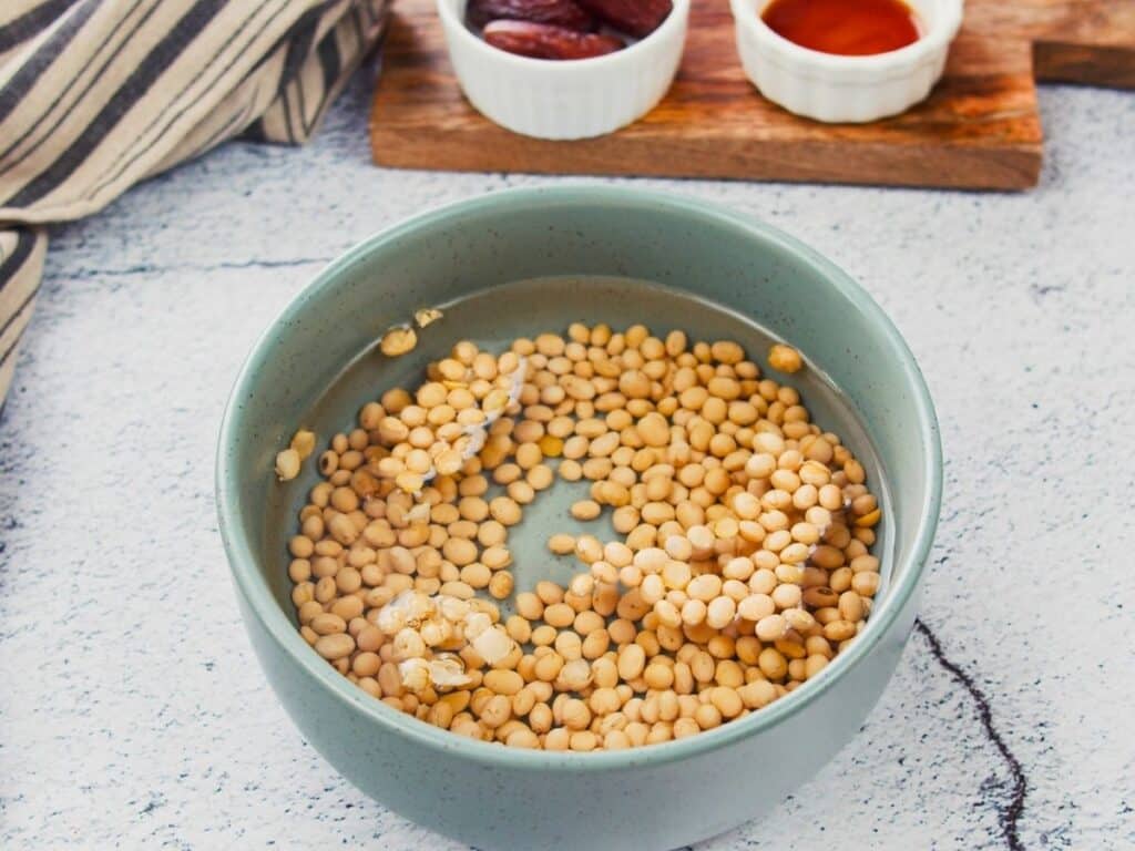 soy beans soaking in blue bowl of water