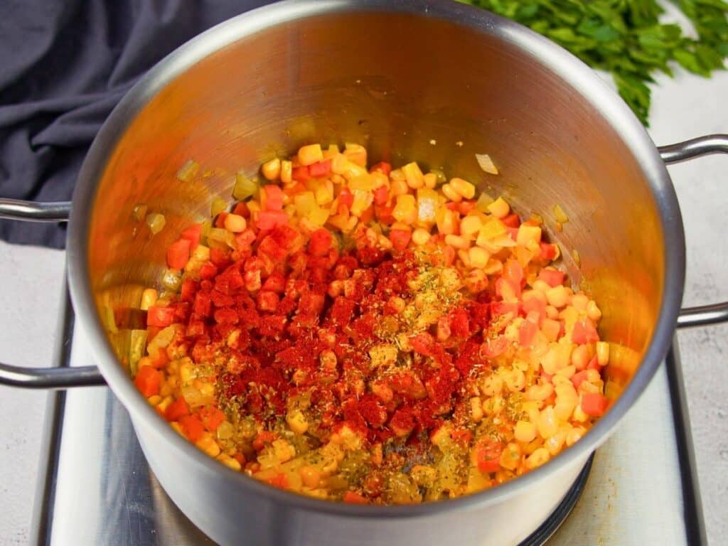 spices on top of cooked vegetables in stockpot