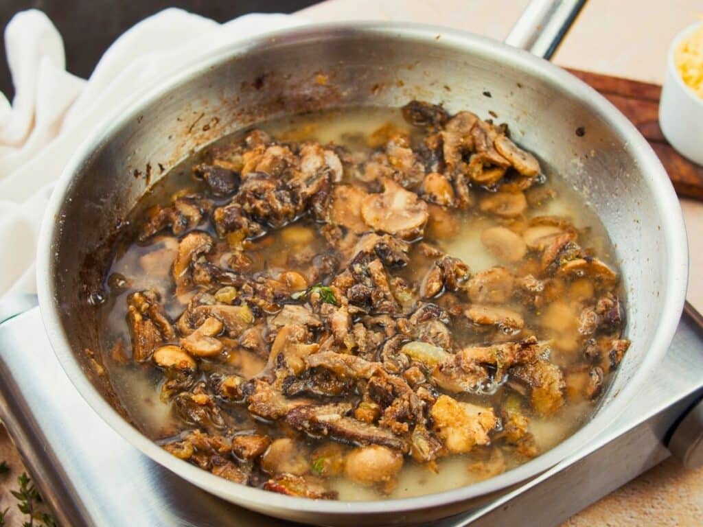 broth and mushrooms in skillet