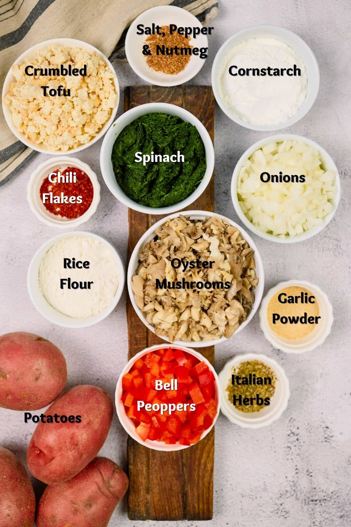 round ramekins of ingredients on marble table next to potatoes