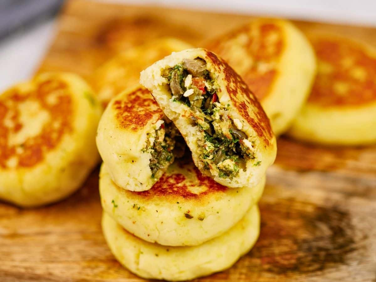 stack of stuffed potato cakes on cutting board