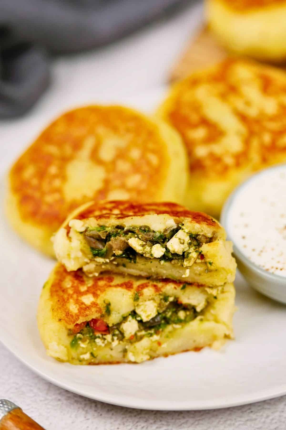 plate holding potato cakes with one in foreground cut in half and stacked