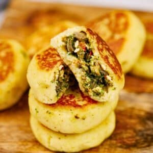 stack of stuffed potato cakes on cutting board