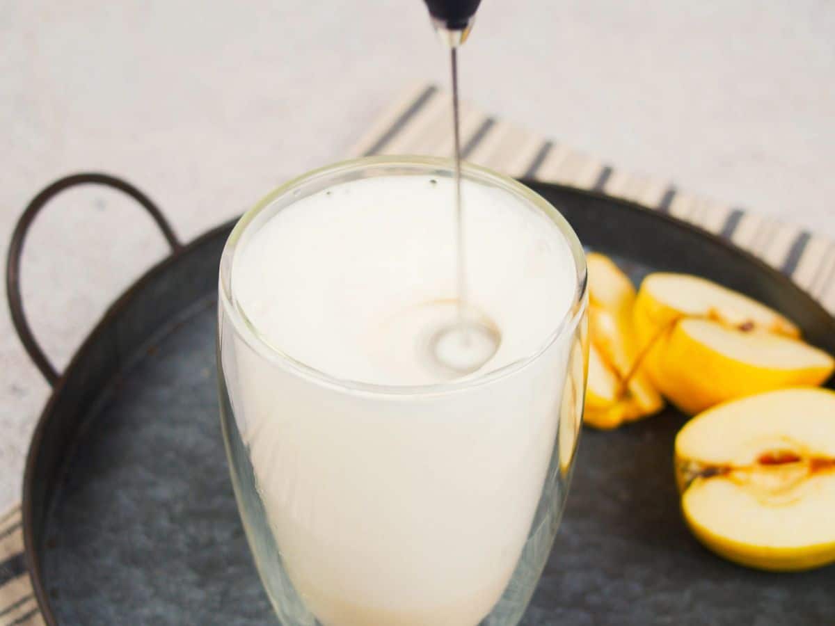 frother held above glass of milk