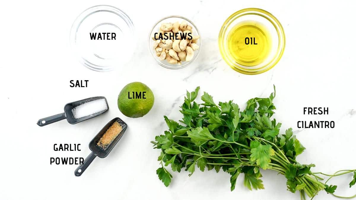 bowls of ingredients on white table beside bunch of fresh herbs