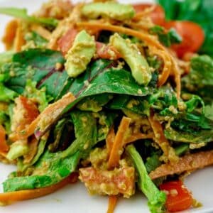 salad with shredded carrots in cream sauce on white plate