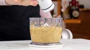 lid being removed from food processor full of chickpea puree