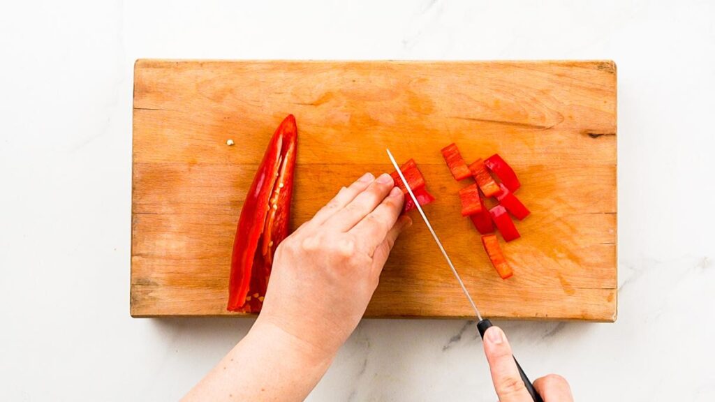 red pepper being sliced on cutting board