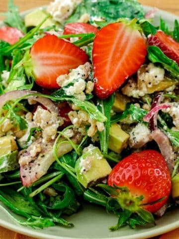 light green plate of farro summer salad topped with berries