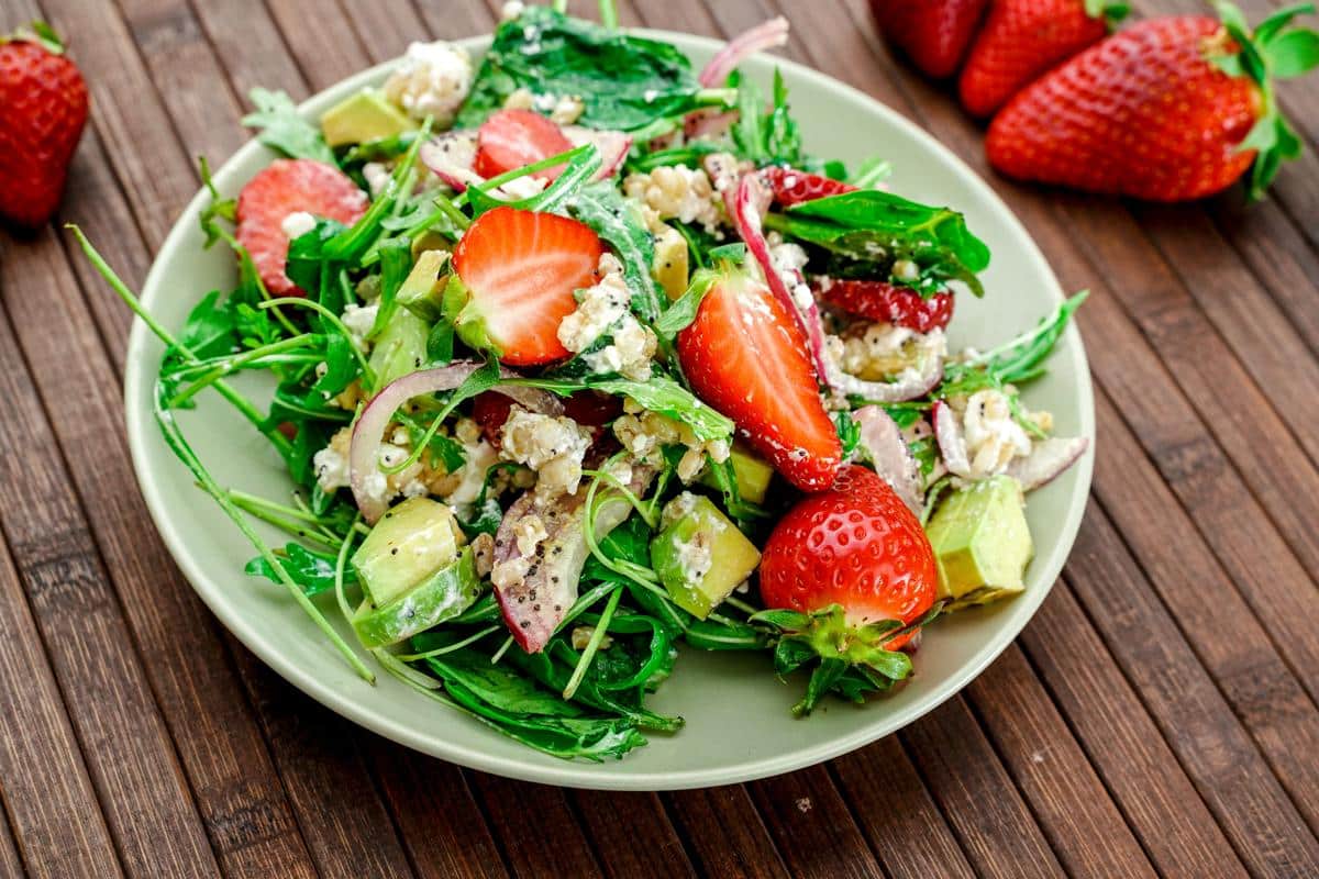 light green plate of salad on wood table