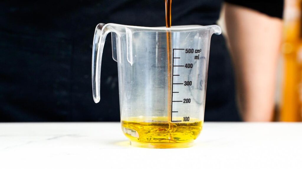 oil being poured into measuring cup