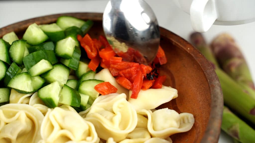 roasted pepper being added to bowl 