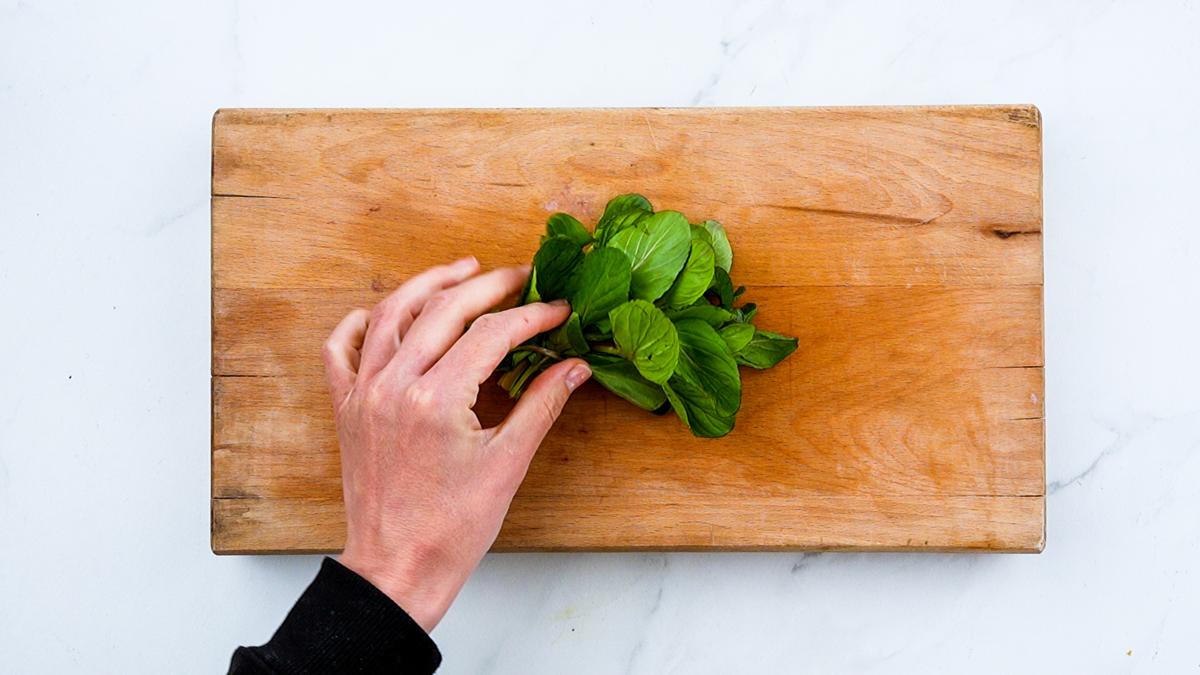 chopping fresh basil on cutting board