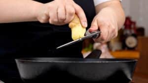 hand grating ginger into wok