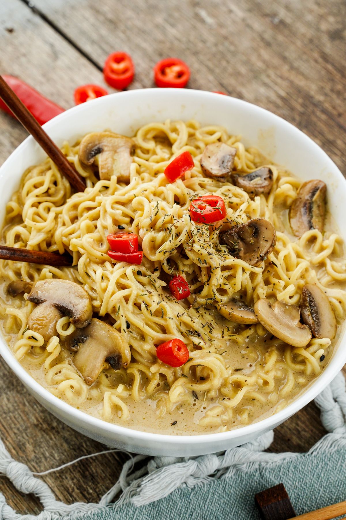 large white bowl of Thai peanut Ramen with chopstick in side and mushrooms on top