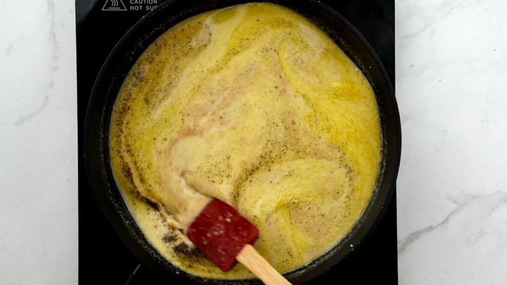 broth being stirred in wok on hot plate