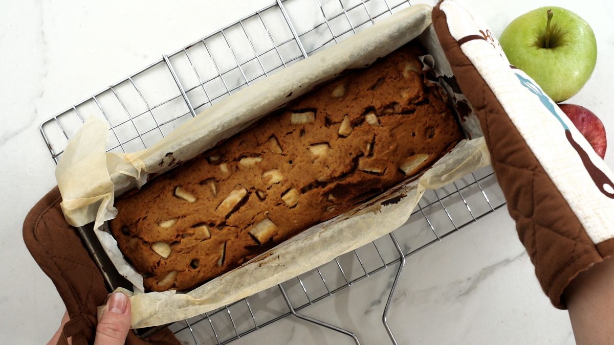 baked apple bread in baking pan on top of wire rack