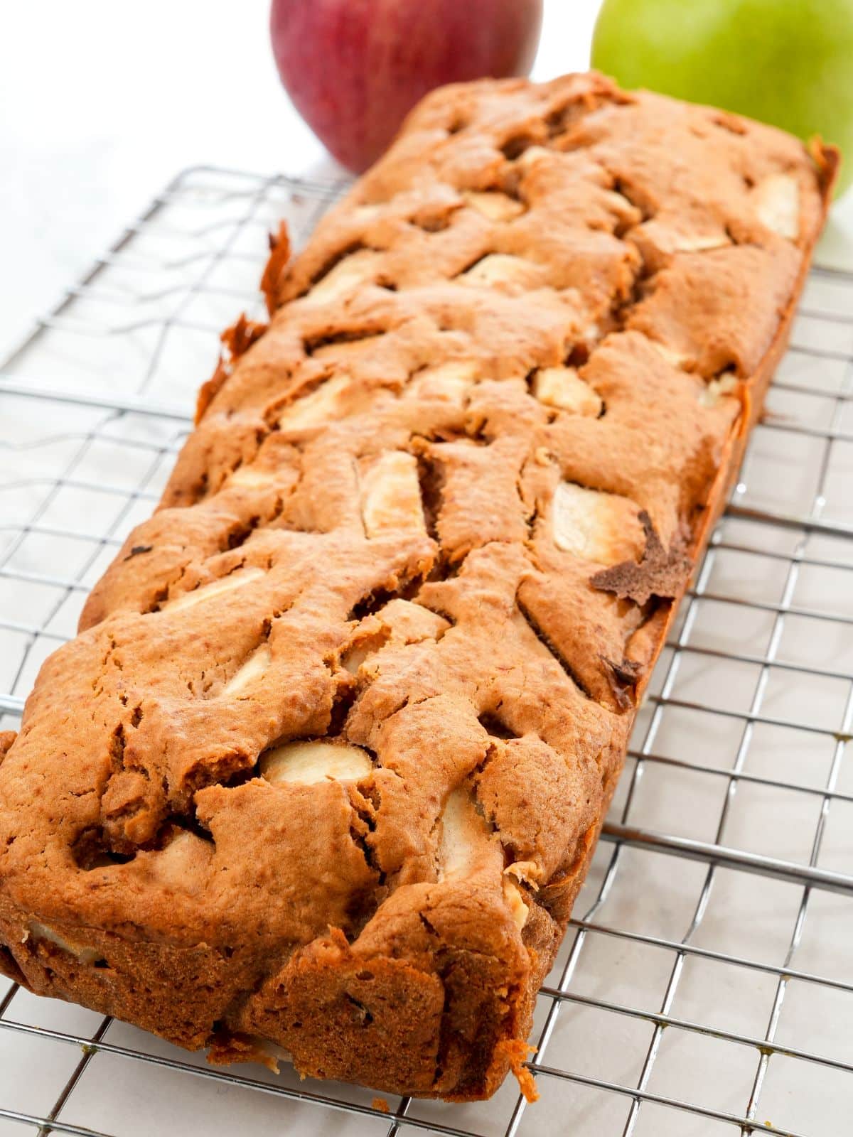 wire rack on white table holding loaf of vegan apple pie bread